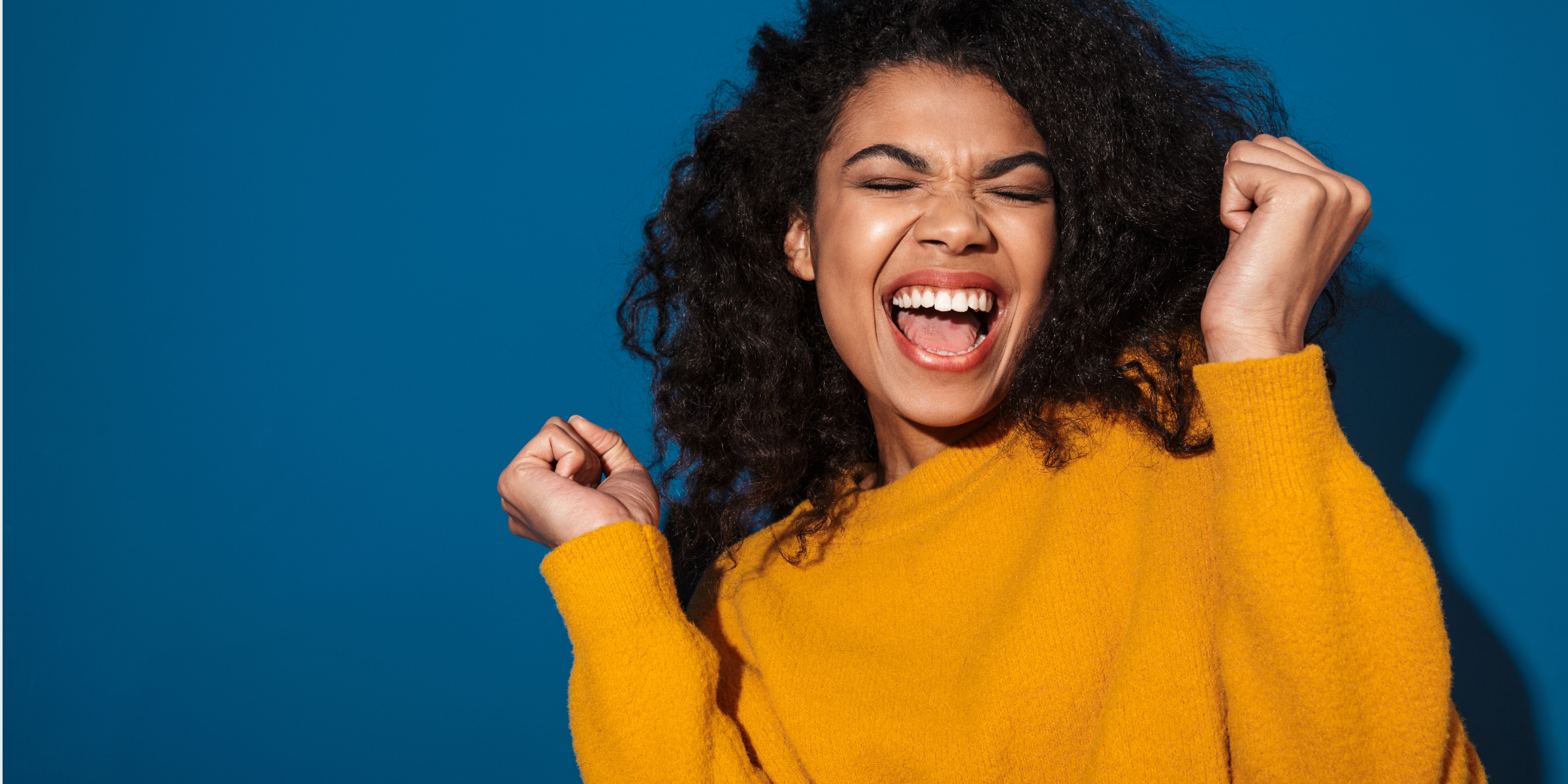 The Transplant Doula - Woman in Yellow Sweater Against Blue Background, Exclaiming Excitement
